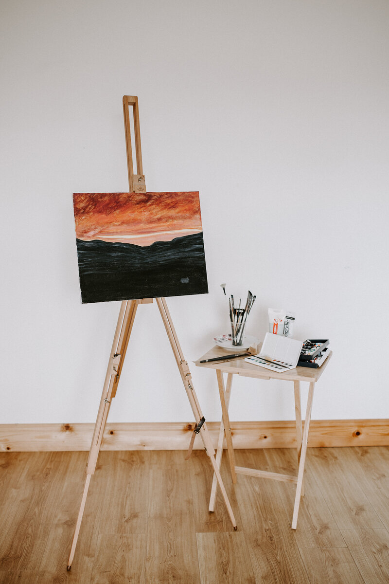 A painting by Seána Redmond displayed on an easel, inspired by Irish history, culture, and landscape