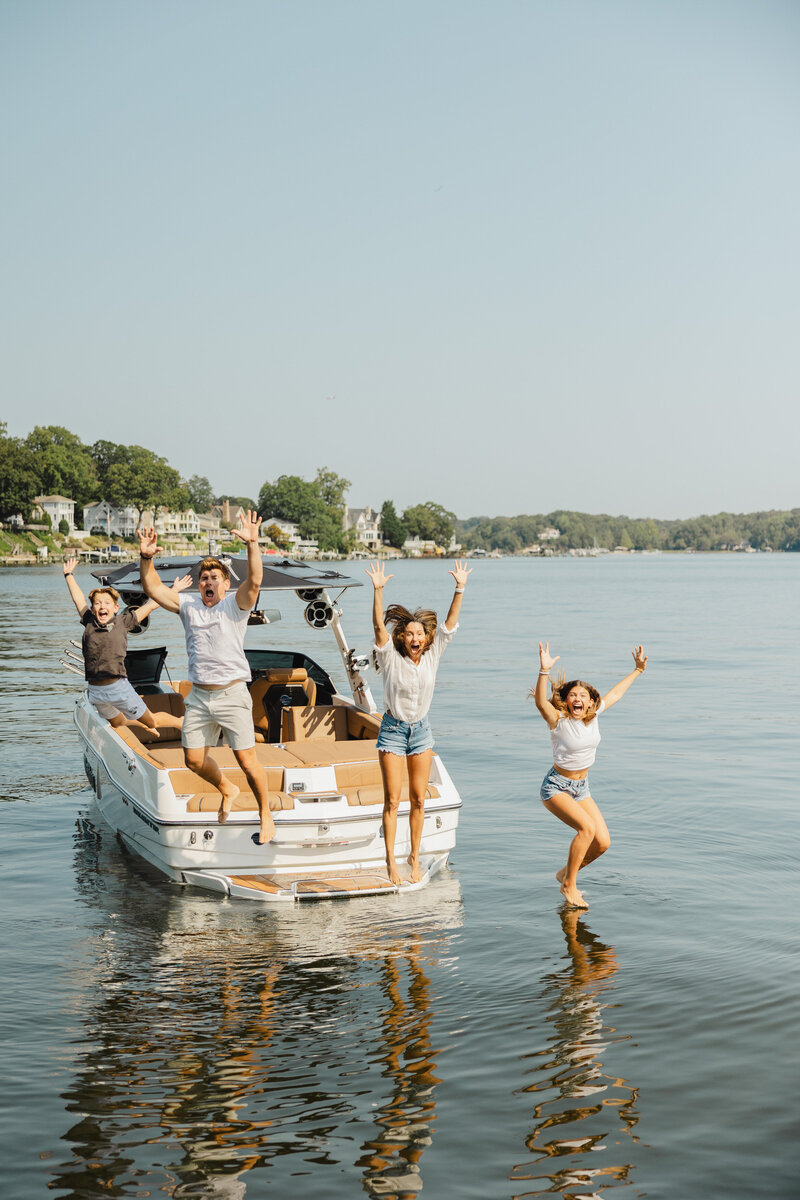 A family jumping off the back of a boat together 