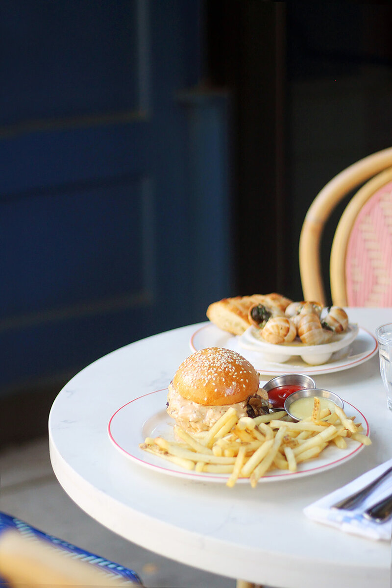 Burger and fries plated on a bistro table