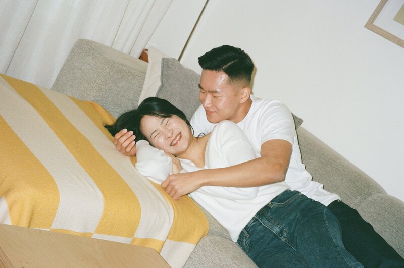 in home session couple laughing and hugging on the couch