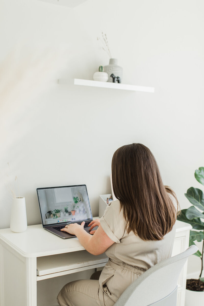 Lena, working on a laptop at a home office desk