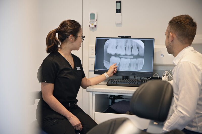 dentist showing tooth x-rays to patient