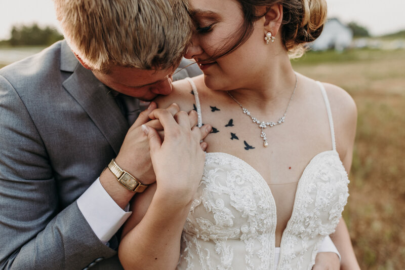 groom kissing brides shoulder