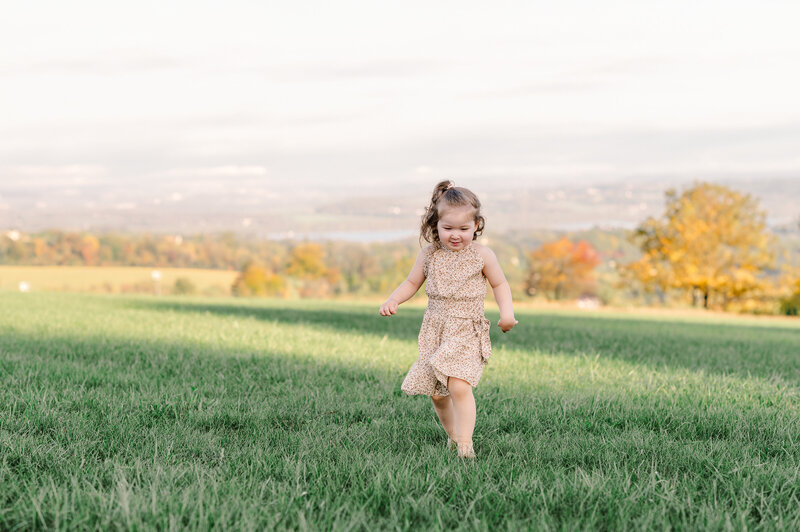 girl running in grass by photographers baltimore md