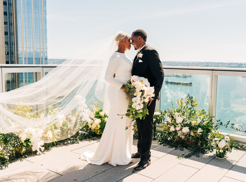 black wedding couple poses on rooftop near seattle waterfront