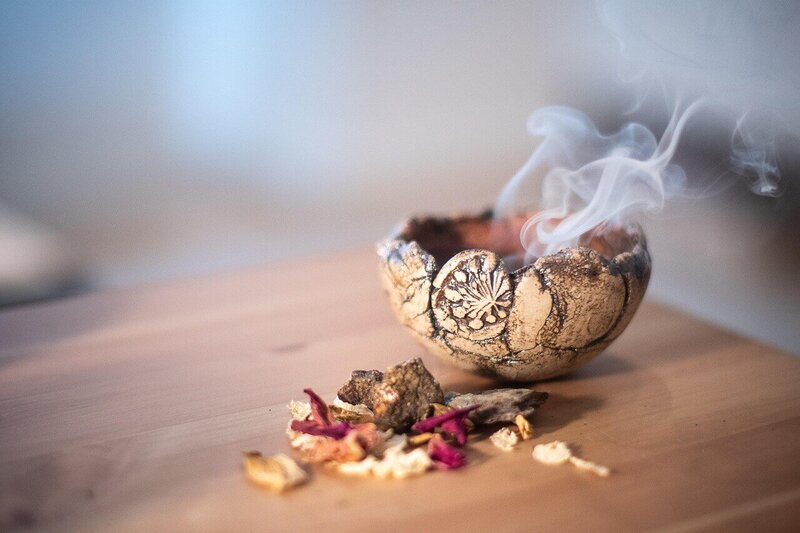 Incense bowl with smoke and dried herbs