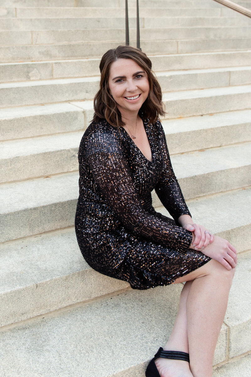 Woman smiling sitting on stairs at branding shoot.