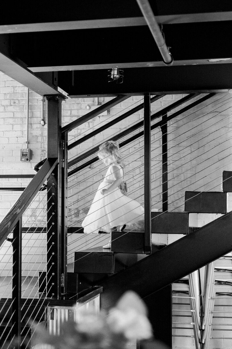 a young flower girl walking down steps