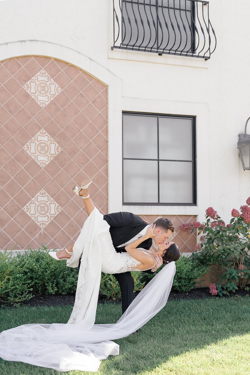 Columbus wedding photographer captures groom picking up his bride and dipping her back a little and kissing her passionately