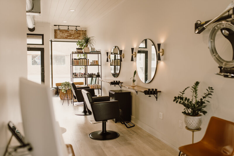 Modern and inviting hair salon interior with styling chairs, mirrors, and shelves featuring Davines hair products in Fort Wayne.