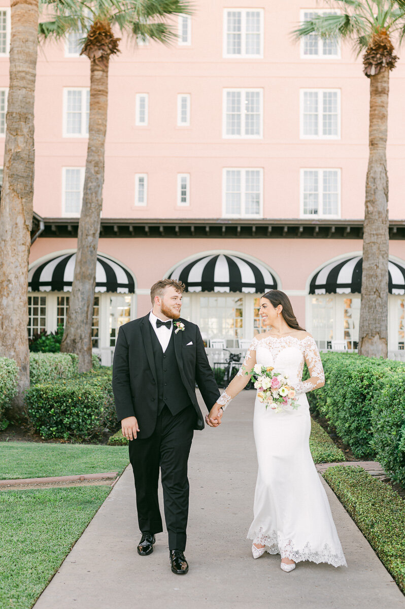bride and groom walking outside Grand Galvez