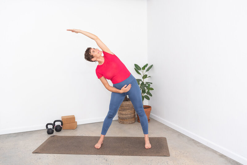 A woman in yoga attire doing a yoga pose on her mat.