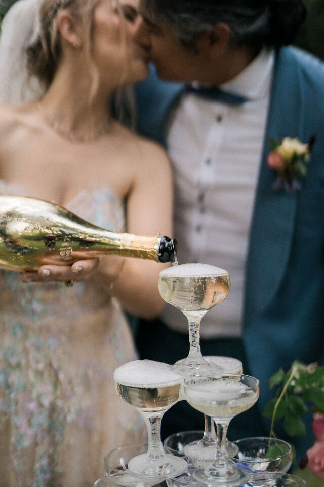 Bride and groom champaign tower pour and kiss