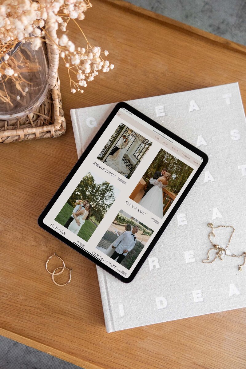 An ipad sits by earrings and a necklace on a desk, and portrays a portfolio page designed as part of a custom web design package. 
