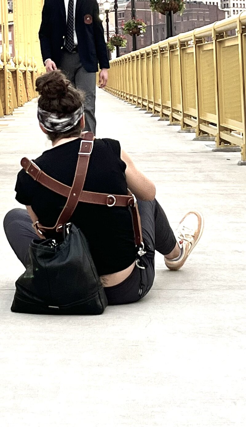 Heidi takes photographs of a high school senior boy on the Roberto Clemente bridge in Pittsburgh.