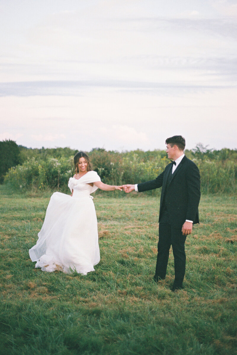 film photo bride and groom dancing in green field at marblegate farm
