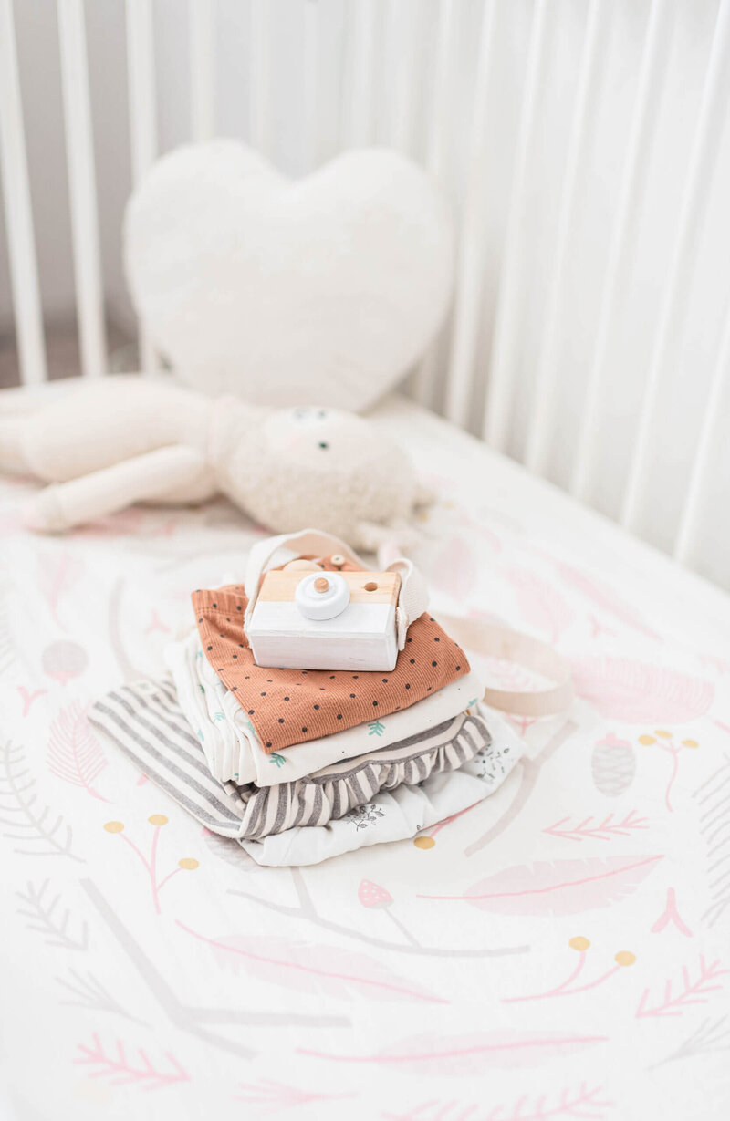 A baby monitor on a dotted blanket beside a plush toy.