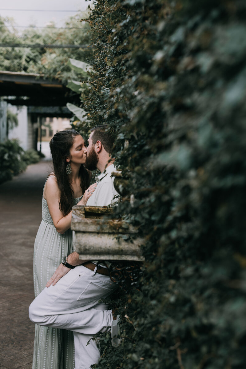 Couple shares a kiss during their engagement photo session  in downtown Fairhope, Alabama.