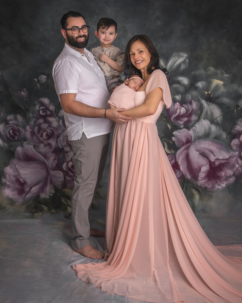 "A heartwarming family portrait with parents and their newborn baby, captured in a timeless and elegant fine art photography session in Ottawa."