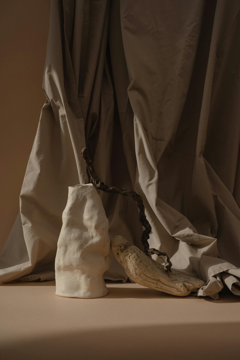 A curated composition of earthy browns and creams with organic textures, pottery, and soft curtains, visually reinforcing The Emerson Boutique Hotel’s brand identity and sophisticated design aesthetic.