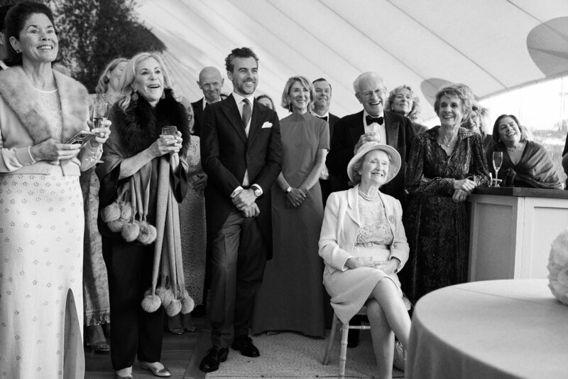 wedding guests laughing inside a marquee
