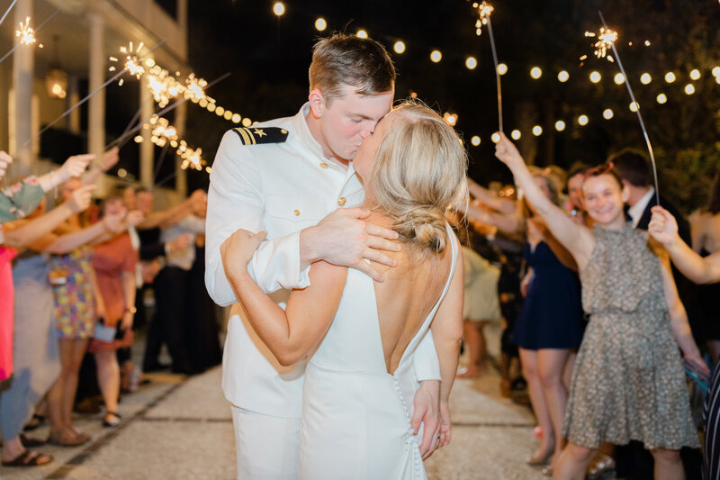 Military wedding sparkler exit with bride and groom kissing