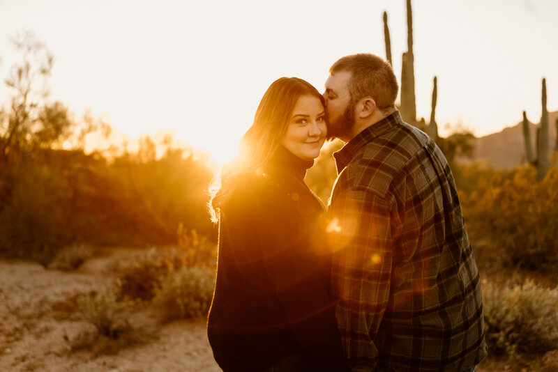 man kisses woman on cheek at golden hour