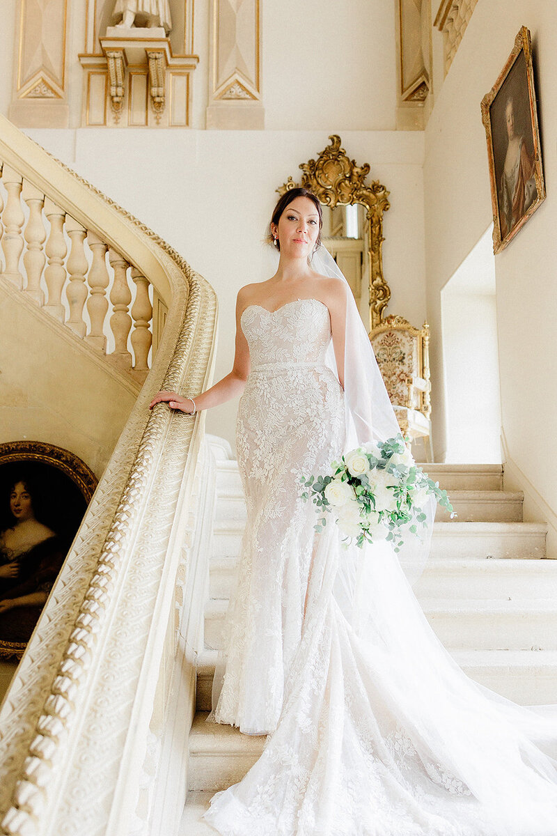 Bride standing on staircase of a French chateau