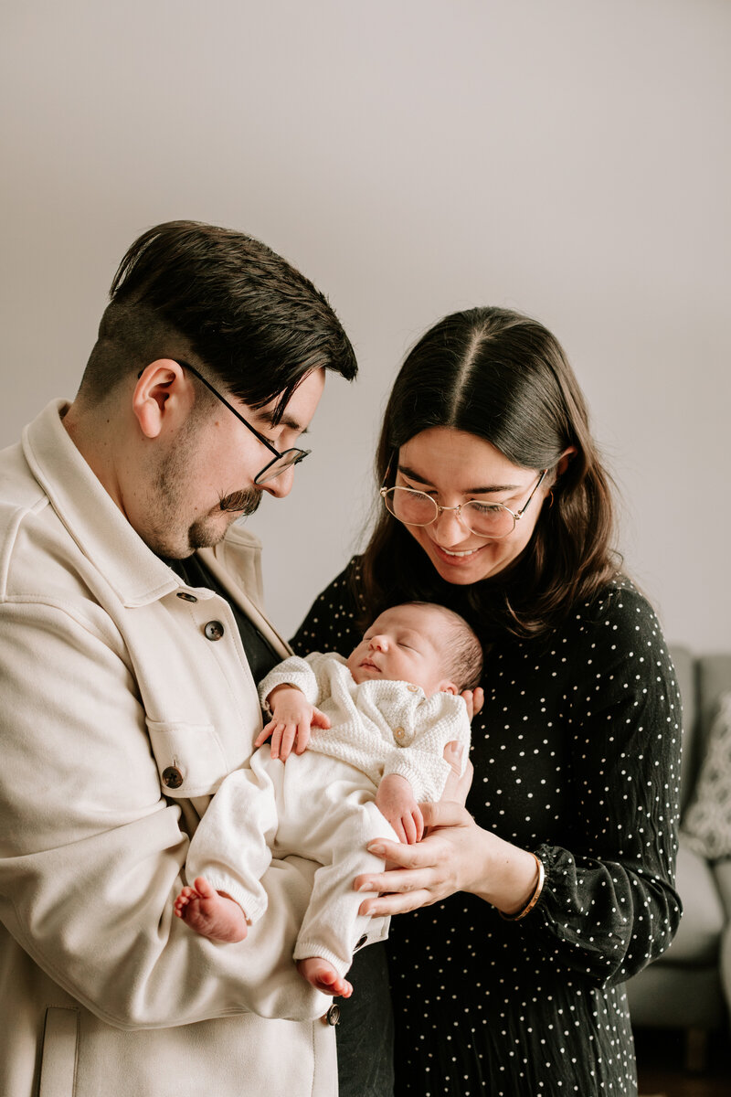 New parents holding their baby girl at home 