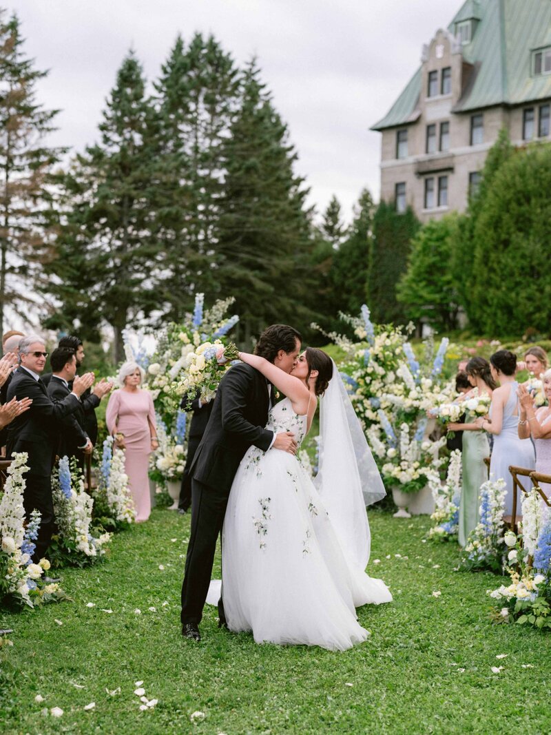 Newlyweds kissing during wedding recessional