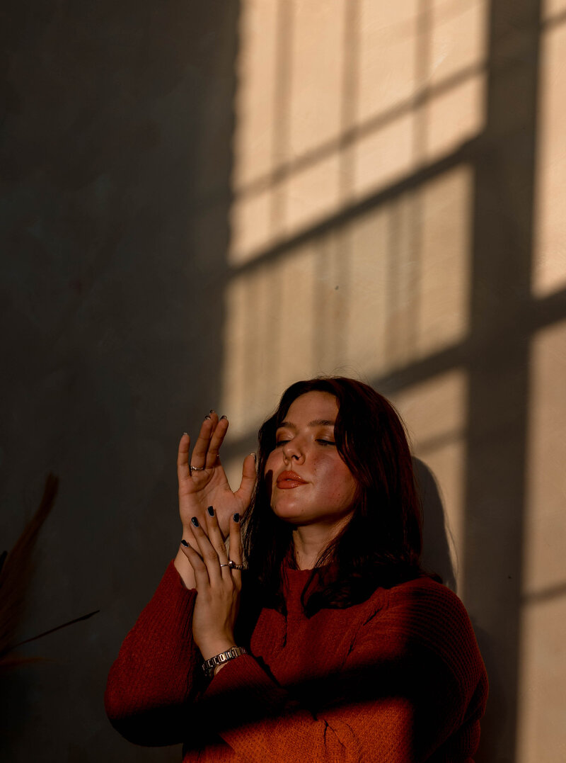 Woman in orange sweater during golden hour in a photography studio