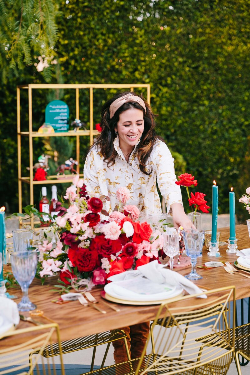 woman sets a rose themed table setting