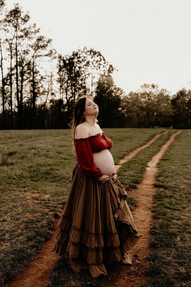 mother posting for maternity photos holding her belly.