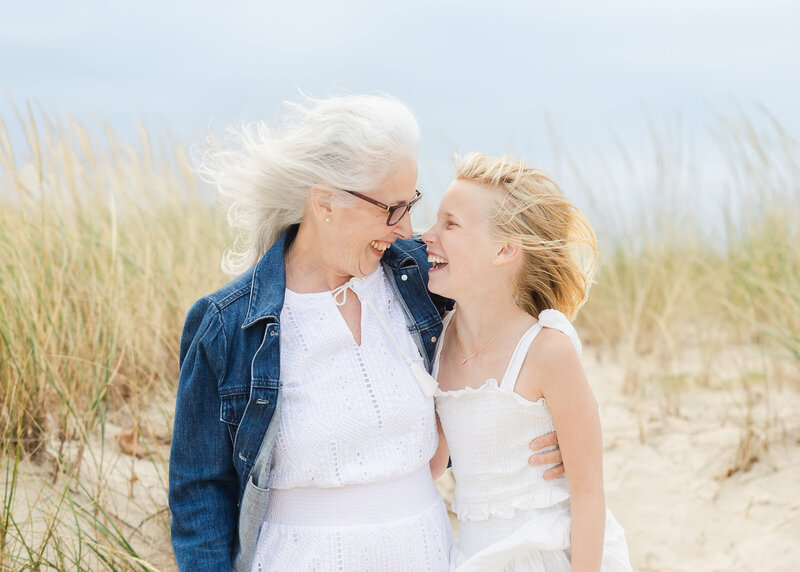 Grandmother and Granddaughter laughing on beach at the NJ shore.