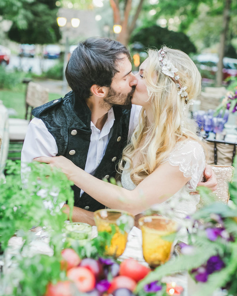 Couple shares a kiss sitting down at a table
