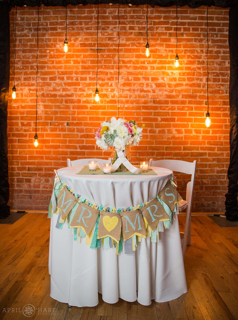 2nd Floor of the BMOCA set up with Sweetheart Table with industrial lights and exposed brick backdrop
