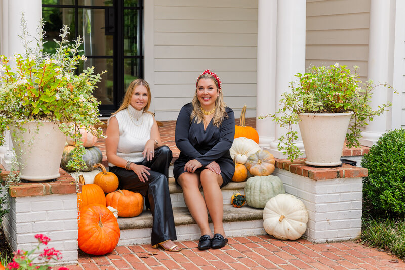 women relator team sitting in a house front door steps surrounded by pumpkins during photoshoot Atlanta by Laure Photography