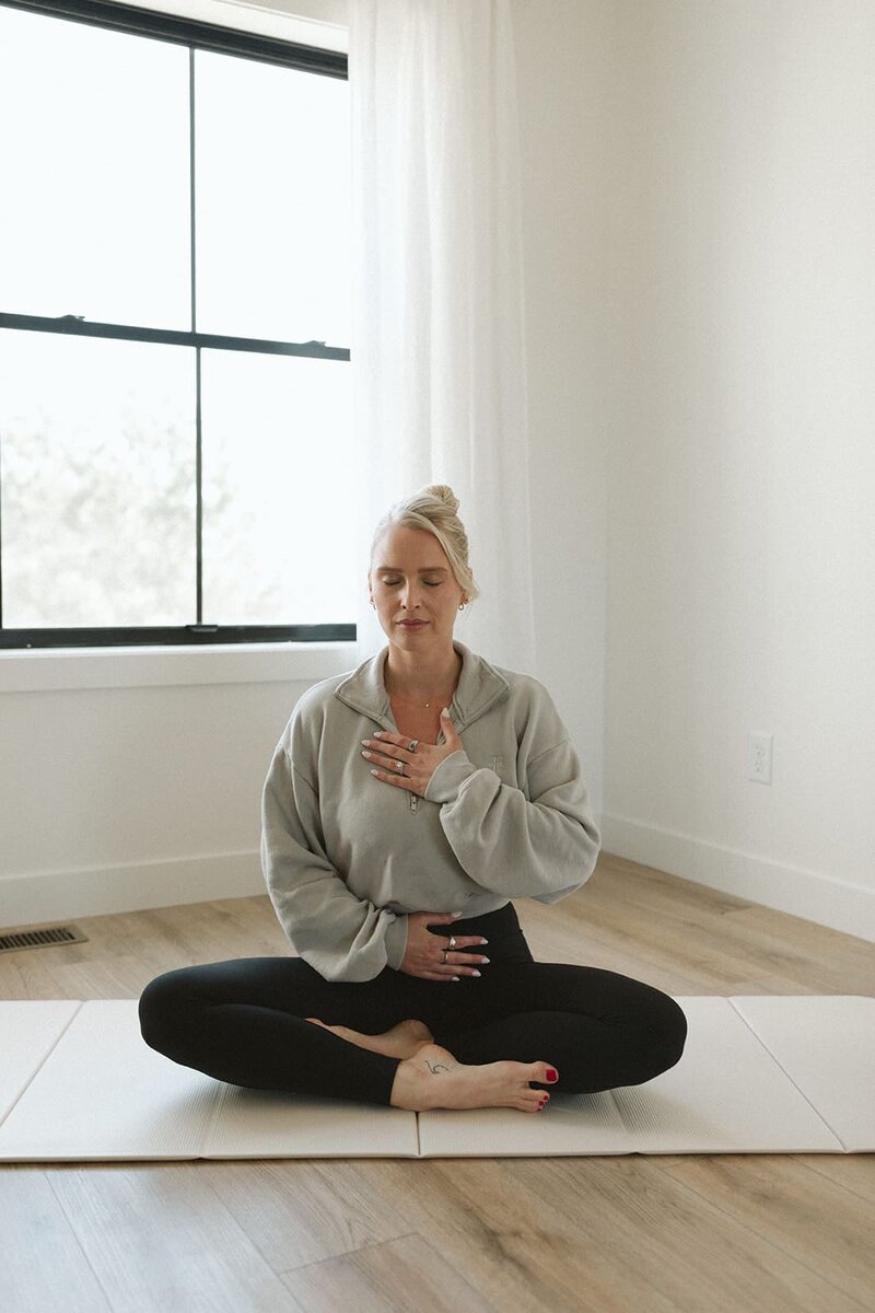 Lauren sitting in stillness, hands on heart and belly—part of a guided practice inside the Studio Only You membership