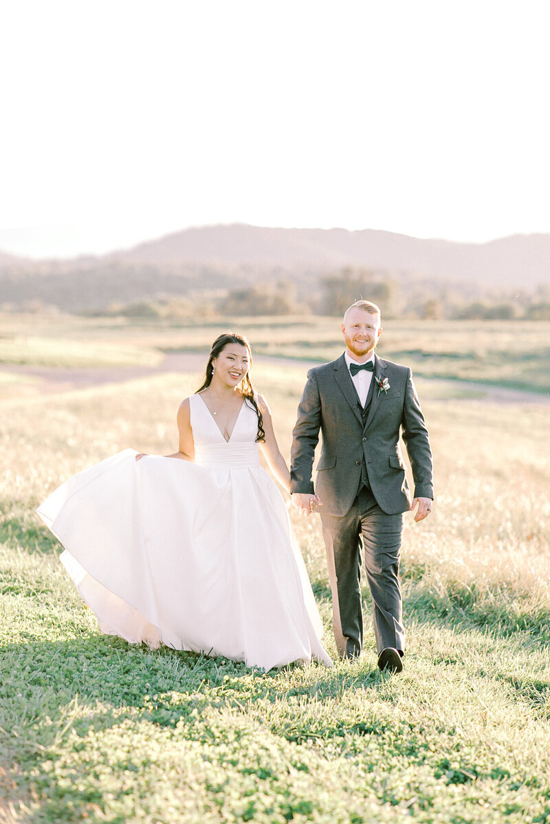 Bride and groom holding hands under umbrella at Silverbrook Farm captured by Virginia Wedding Photographer Sarah Botta Photography