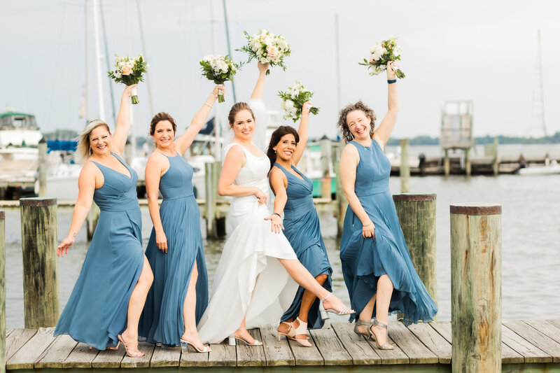 Bridal party having run with their bouquets at Annapolis Maritime Museum, Maryland Wedding