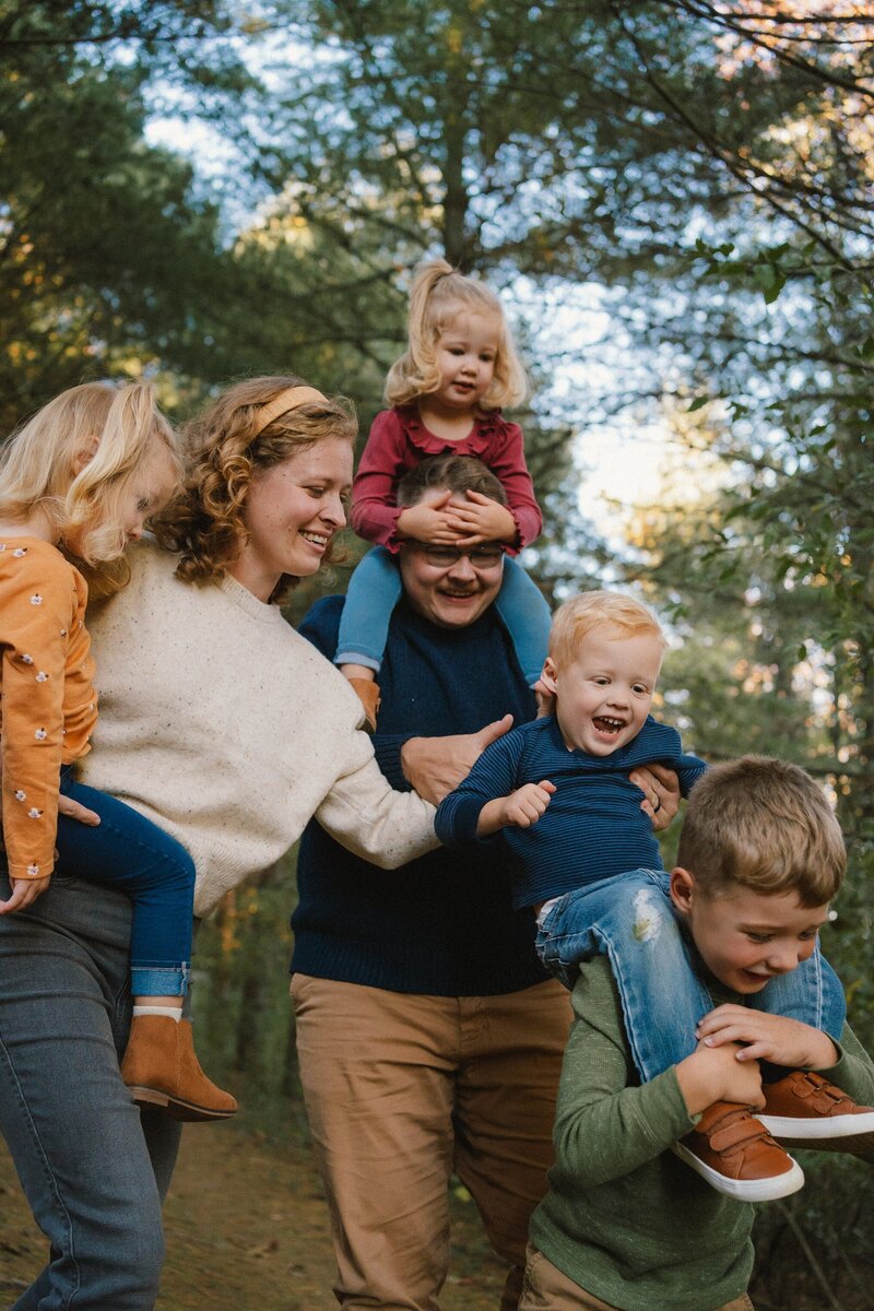 image of tattooed family playing on the bed  by charlottesville family photographer leah oconnell