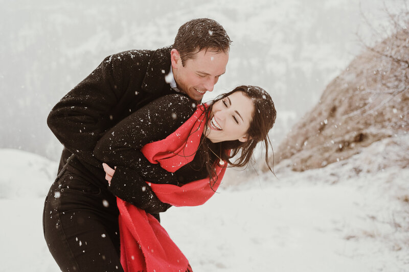 Engagement couple plays in the snow in Ouray, Colorado
