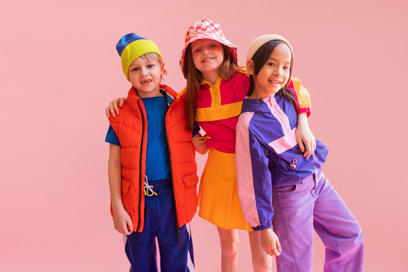 Three happy kids wearing bright and colorful outfits