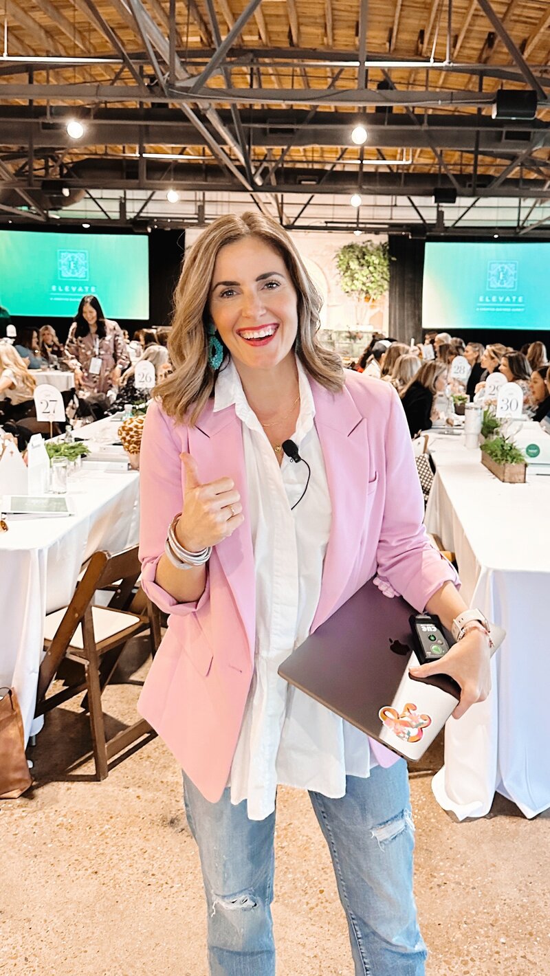 woman leaning over a planner with a pink pin and a green background
