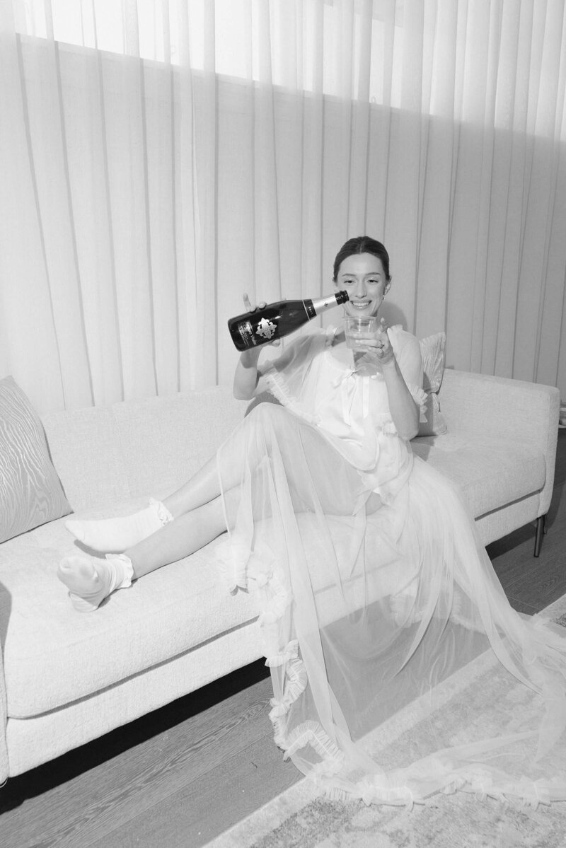 bride pouring a drink while sitting on couch