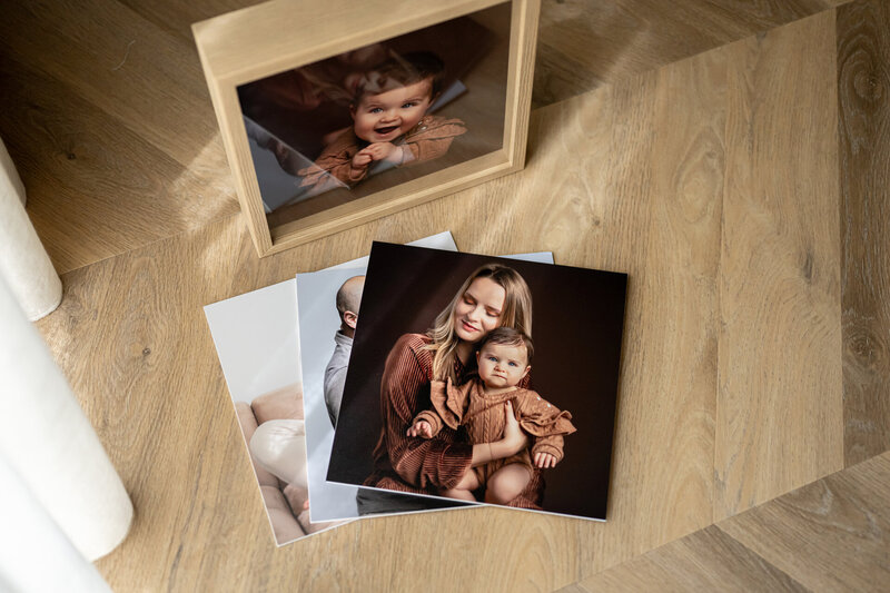 Losse afdrukken die voor de fotobox liggen.