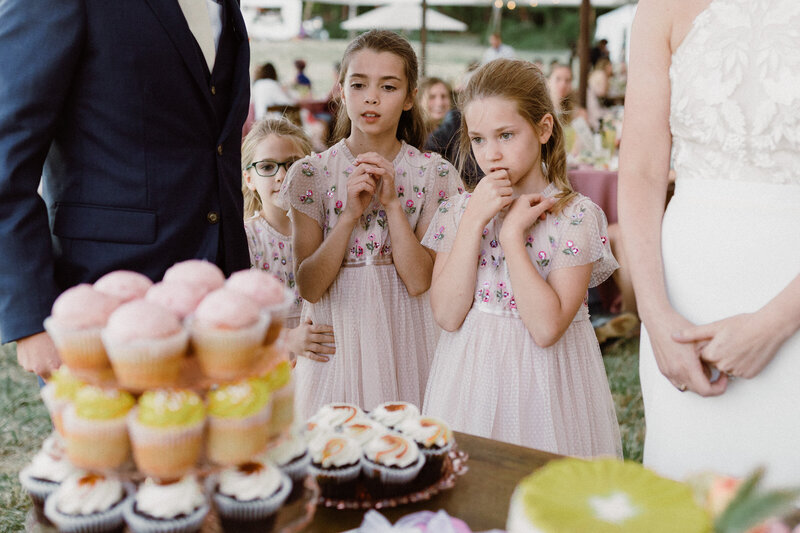 Flowers girls looking  at cupcakes.