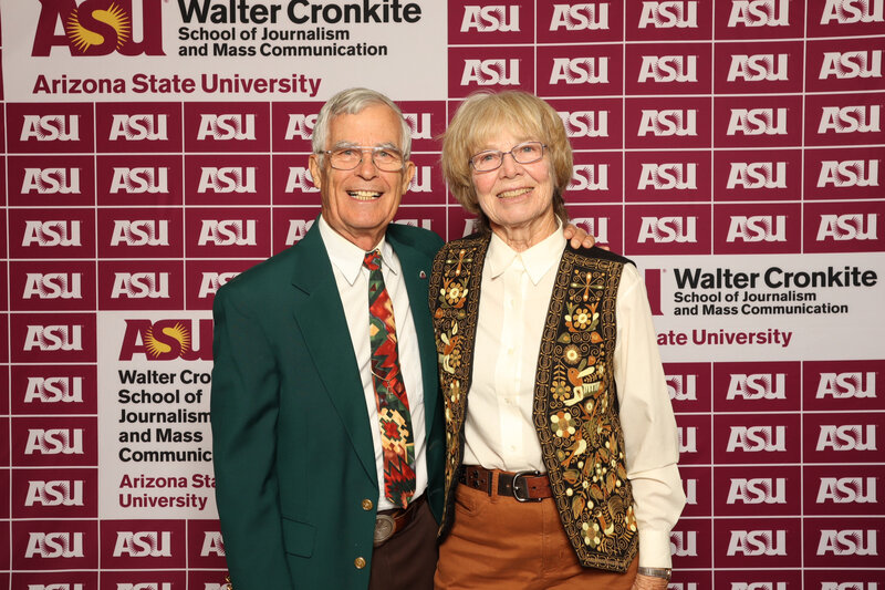 Smiling couple poses in front of an ASU Walter Cronkite School step-and-repeat banner at a university event—captured by MISGIF’s Phoenix-based corporate photographers.