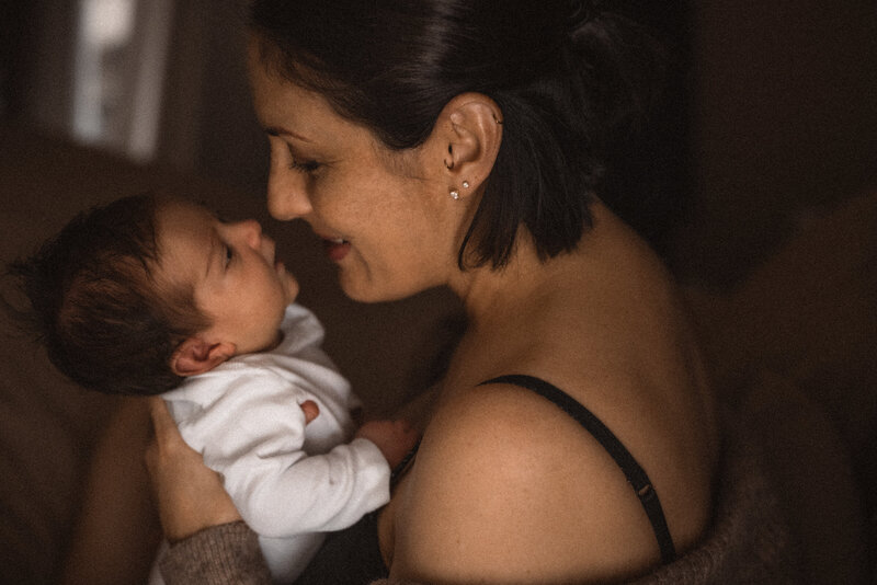 Mother smiling at newborn baby