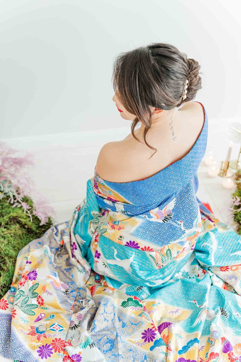 Bride in bright colourful blue kimono looking over her left shoulder
